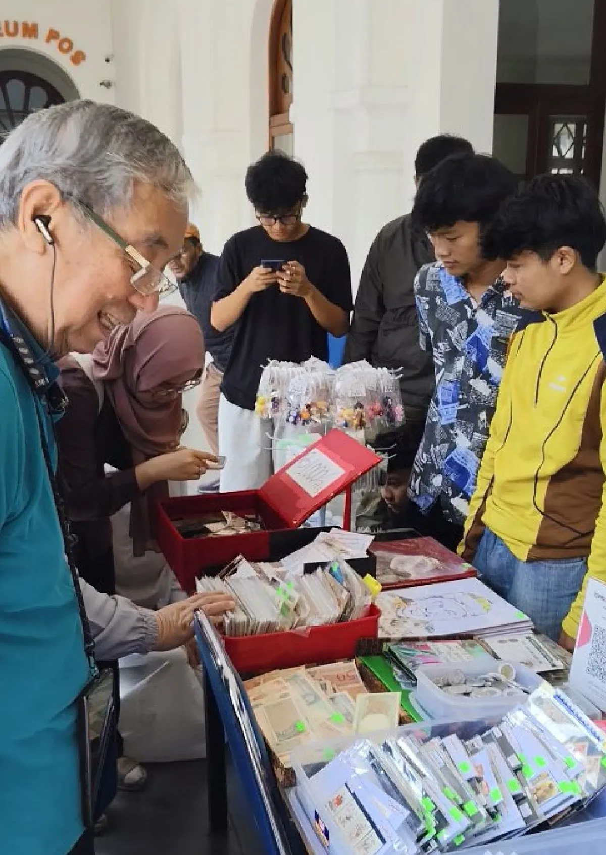 Pengunjung antusias berburu perangko, kartu pos, dan benda filateli langka dalam bursa yang mempertemukan kolektor lintas generasi. (Foto: Maya Maulyda)