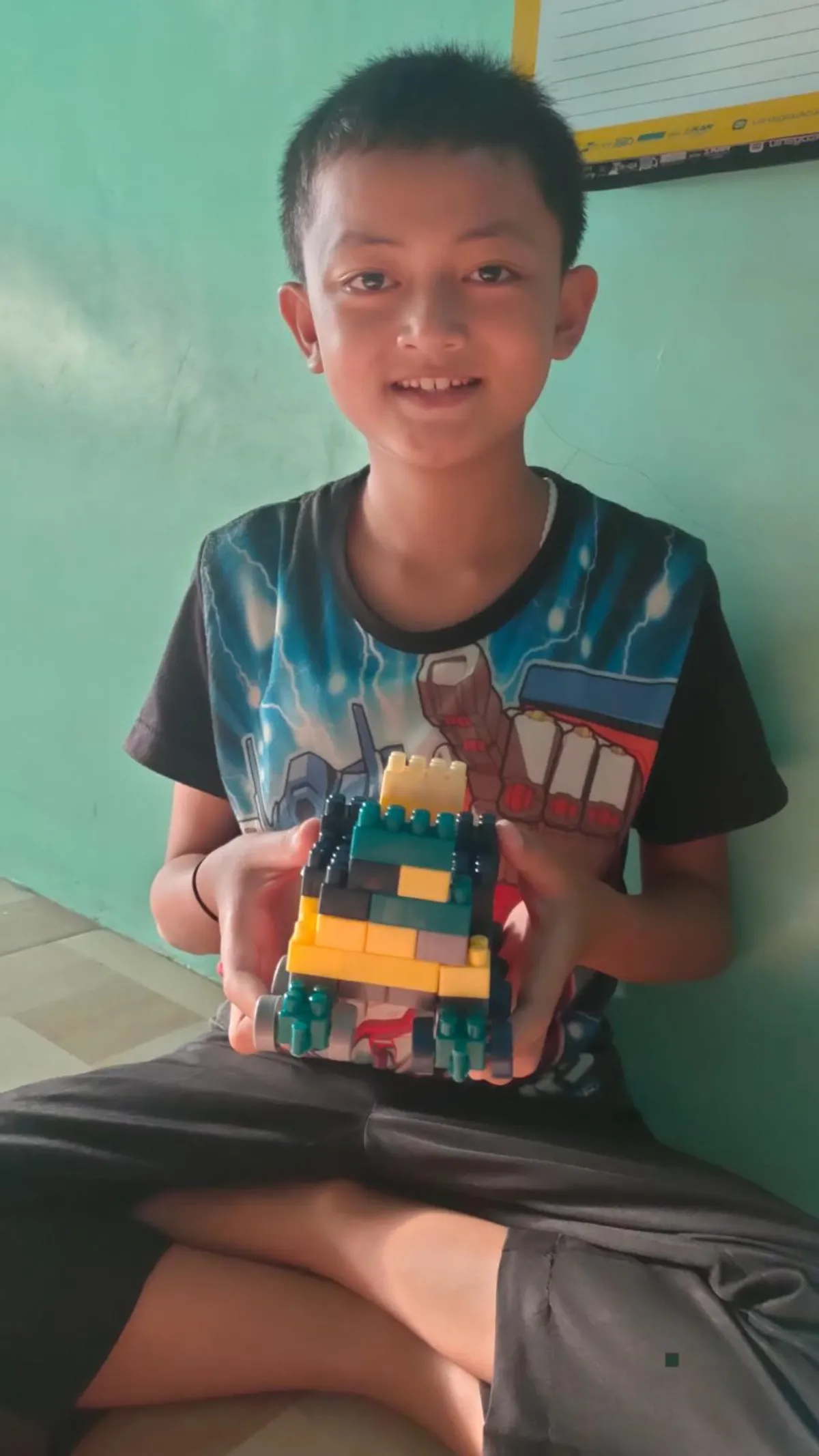 Aa Akil tengah memperlihat hasil kreasi bermain lego, Sabtu (12/7/2025). (Sumber: Istimewa | Foto: IBN GHIFARIE)