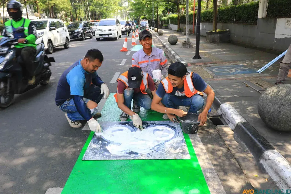 Pengecatan ulang garis jalur khusus sepeda di Jalan Perintis Kemerdekaan, Kota Bandung, Rabu 10 Juli 2024. (Sumber: Ayobandung.com | Foto: Irfan Al-Faritsi)