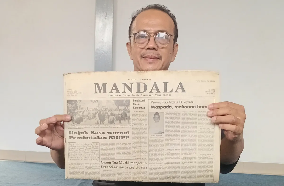 Penulis menunjukkan koleksi arsip koran MANDALA terbitan 32 tahun silam, mengenai pembatalan SIUPP tiga media cetak. (Sumber: Dokumentasi Penulis | Foto: Kin Sanubary)