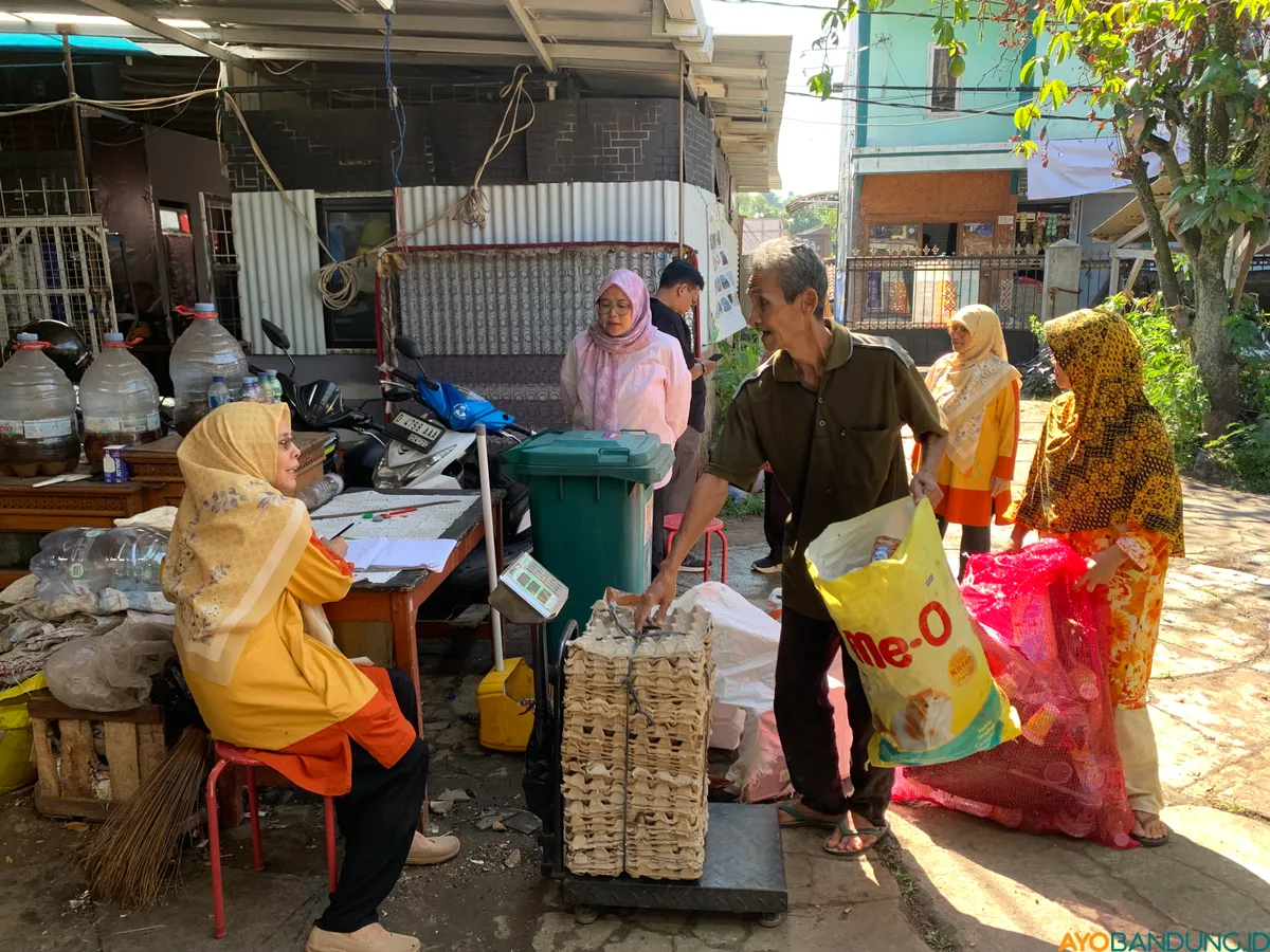 Warga menyetorkan sampah anorganik ke Bank Sampah Ikhtiar 15 Jatihandap, Kota Bandung, yang kemudian ditimbang dan dicatat sebagai saldo tabungan. (Sumber: ayobandung.id | Foto: Halwa Raudhatul)
