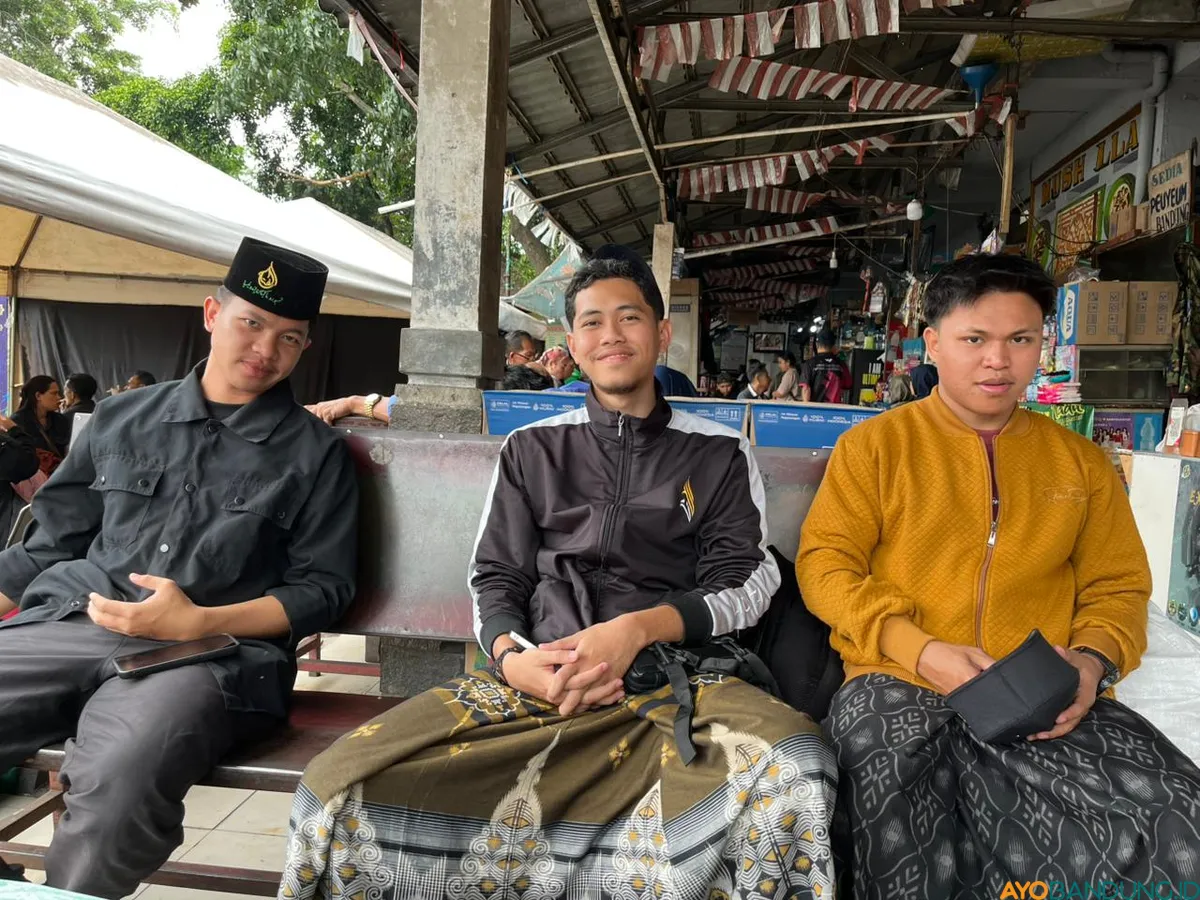 Menunggu bus berangkat, Malik menikmati jeda dengan camilan khas Bandung, di terminal yang kini terasa lebih sunyi. (Sumber: ayobandung.id | Foto: Ilham Maulana)