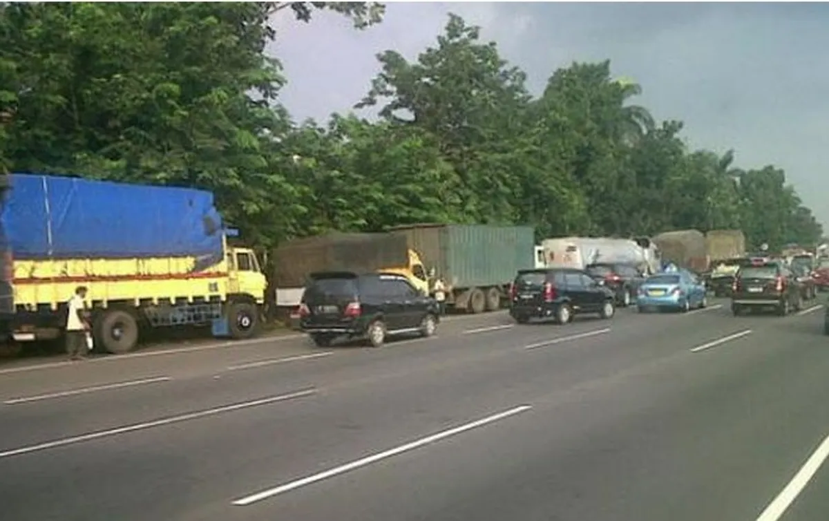Rest area yang penuh memaksa truk-truk parkir di bahu jalan tol. (Sumber: Tribunnews.com/Andri Malau)