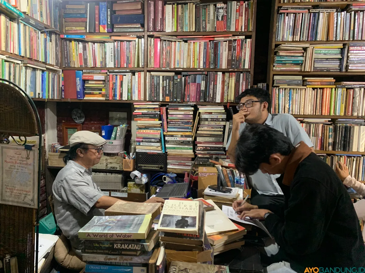 Pengunjung memanfaatkan koleksi buku alternatif di Perpustakaan Batu Api untuk kebutuhan riset dan bacaan pribadi. (Sumber: ayobandung.id | Foto: Halwa Raudhatul)
