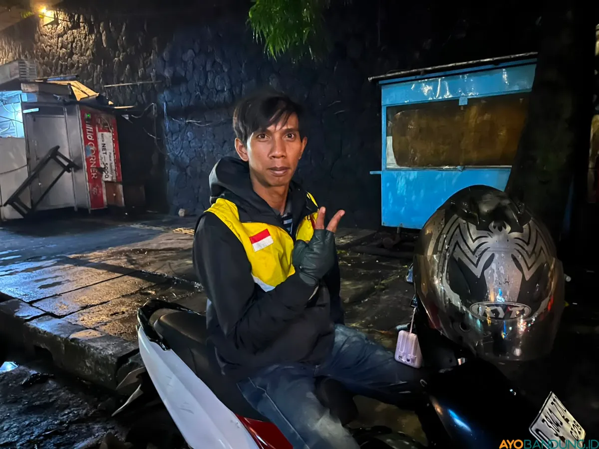 Aji tetap menarik penumpang di tengah konvoi Persib sambil menikmati suasana kemenangan Kota Bandung. (Sumber: ayobandung.id | Foto: Ilham Maulana)