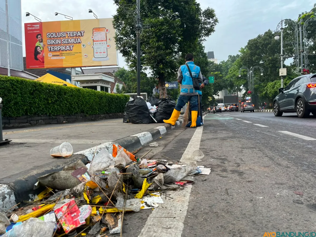 Sampah botol plastik, sisa makanan, dan bekas flare terlihat berserakan di sejumlah ruas jalan Kota Bandung selepas konvoi Persib. (Sumber: ayobandung.id | Foto: Ilham Maulana)