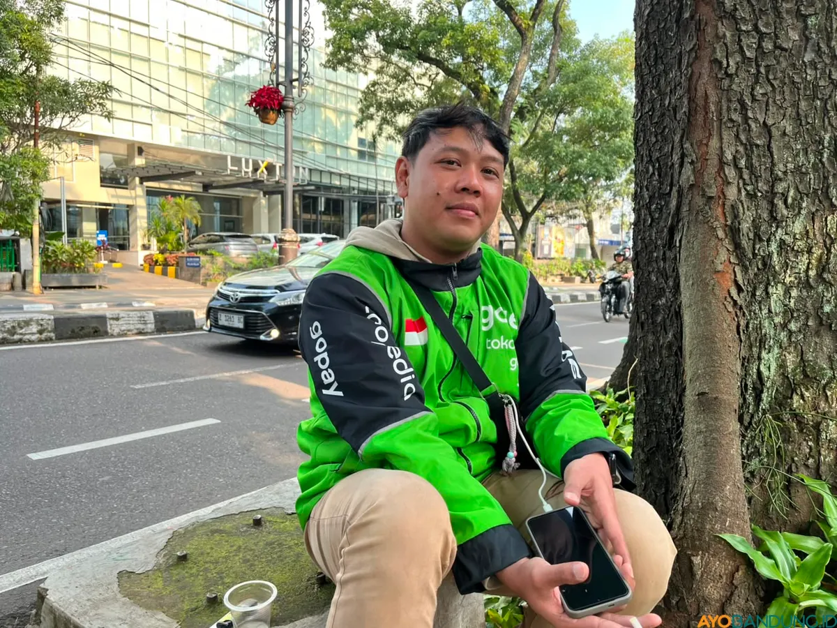 Hasanuddin memilih tetap menggunakan motor bensin demi fleksibilitas saat menerima order perjalanan jauh. (Sumber: ayobandung.id | Foto: Ilham Maulana)