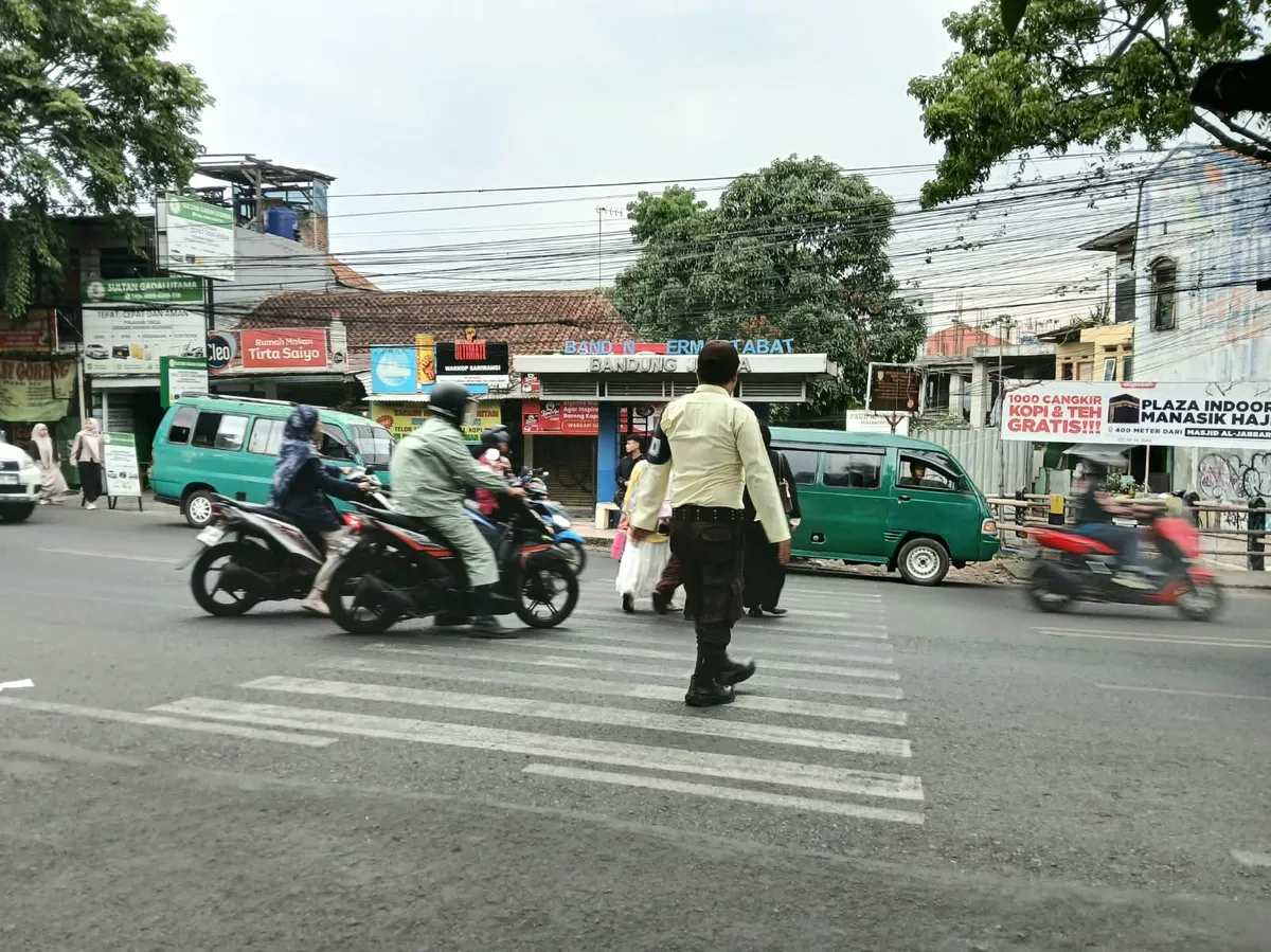 Momen ketika satpam membantu mahasiswa menyeberang melalui zebra cross tersebut. Difoto pada hari Rabu, 7 Oktober 2026 pukul 15.52 WIB. (Sumber: Dok. Pribadi | Foto: Evira Dwi Shakira)