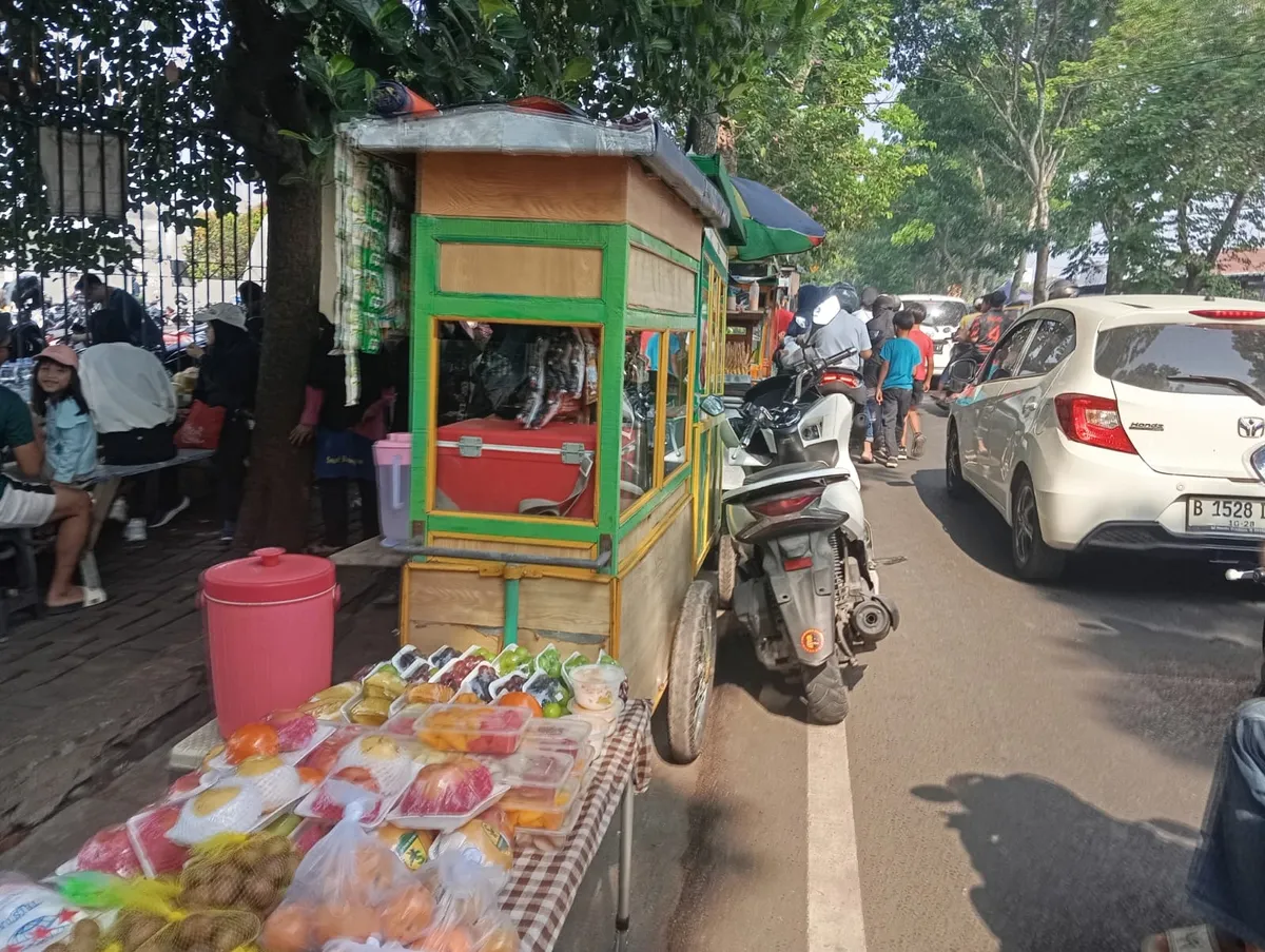 Pejalan kaki berjalan di bahu jalan karena trotoar dipenuhi oleh kegiatan pedagang kaki lima. (Sumber: Pribadi | Foto: Marsya Laura Humaira)