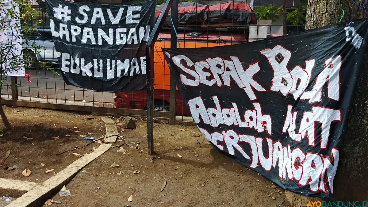 Spanduk terpasang di sudut lapangan sebagai bentuk penolakan warga terhadap rencana perubahan fungsi lapangan sepak bola menjadi ruang publik multifungsi. (Sumber: ayobandung.id | Foto: Gilang Fathun Romadhan)