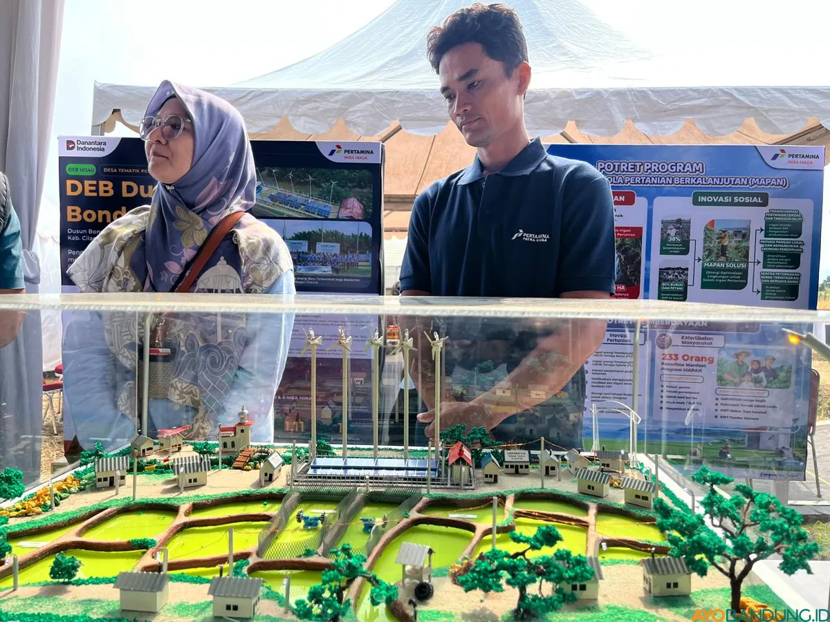 Warga Dusun Bondan, Desa Ujungalang, Kecamatan Kampung Laut, Kabupaten Cilacap menunjukkan mokap instalasi energi bersih program Desa Energi Berdikari PT Pertamina Patra Niaga yang saat ini dikembangkan di kampung tersebut. (Sumber: ayobandung.id | Foto: Arif Budianto)