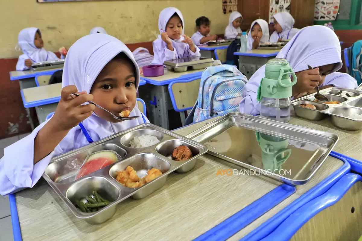 Siswa menyantap hidangan Program Makan Bergizi Gratis (MBG) disalah satu SD Negeri Kota Cimahi, Selasa 14 Juli 2026. (Sumber: Ayobandung.com | Foto: Irfan Al-Faritsi)