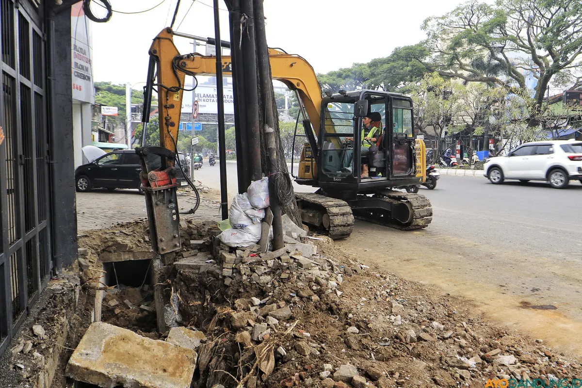 Pekerja membongkar saluran drainase lama yang sudah dipenuhi pasir dan batuan di Jalan Dr. Djunjunan, Kota Bandung, Selasa 29 September 2026. (Sumber: ayobandung.id | Foto: Irfan Al Faritsi)