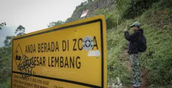 Warga melintas di dekat rambu zona Sesar Lembang di kawasan Gunung Batu, Lembang, Kabupaten Bandung Barat (KBB), Jumat 22 Agustus 2025. (Sumber: ayobandung.id | Foto: Kavin Faza)