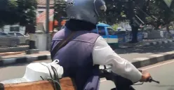 Seorang pengendara motor melaju di jalan Kota Bandung siang hari. (29/10/2024) (Sumber: Khalidullah As Syauqi)