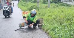 Hasan Fiidel, ojol asal Kabupaten Bandung memperbaiki jalan rusak tanpa duit pemerintah. (Sumber: Ayobandung | Foto: Mildan Abdalloh)