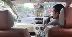 Seorang&nbsp;driver online&nbsp;tengah tersenyum ramah menunggu penumpangnya di tengah keramaian jalanan, menerapkan nilai&nbsp;cageur, bager, bener&nbsp;dalam layanan transportasi – Bandung, Sabtu (01/11/2025) (Foto: Bunga Kemuning A.D)