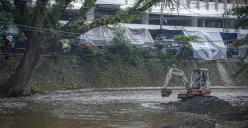 Proses pengerukan sedimentasi Sungai Cikapundung oleh petugas menggunakan alat berat di Kota Bandung. (Sumber: Ayobandung.id | Foto: Kavin Faza)