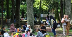 Pegunjung memanfaatkan Kawasan Kebun Binatang Bandung yang rindang dan sejuk untuk berkumpul dan makan bersama. (Sumber: ayobandung.id | Foto: Irfan Al Faritsi)