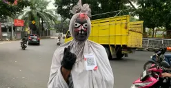 Cosplayer pocong di Lembang memanfaatkan QRIS untuk menerima uang dari warga. (Sumber: ayobandung.id | Foto: Halwa Raudhatul)