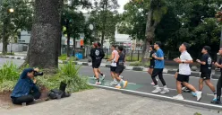 Seorang fotografer mengabdikan para pelari di daerah Dago, Kota Bandung. (Sumber: ayobandung.id | Foto: Ilham Maulana)