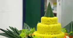 Tumpeng nasi kuning berdiri gagah dikelilingi berbagai lauk pauk dalam acara syukuran keluarga. (Sumber: Unsplash | Foto: Deski Jayantoro)