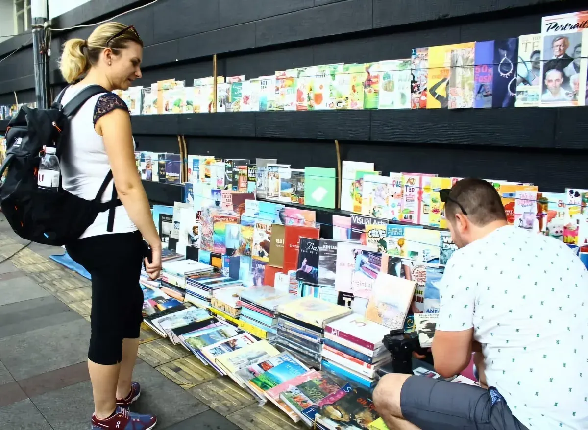 Wisatawan asing saat melihat koleksi buku langka atau edisi lama di Pasar Buku Cikapundung, Kota Bandung. (Sumber: Ayobandung.id)