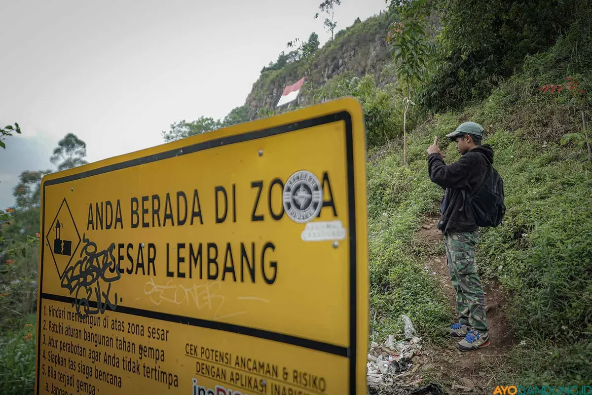 Warga melintas di dekat rambu zona Sesar Lembang di kawasan Gunung Batu, Lembang, Kabupaten Bandung Barat (KBB), Jumat 22 Agustus 2025. (Sumber: ayobandung.id | Foto: Kavin Faza)
