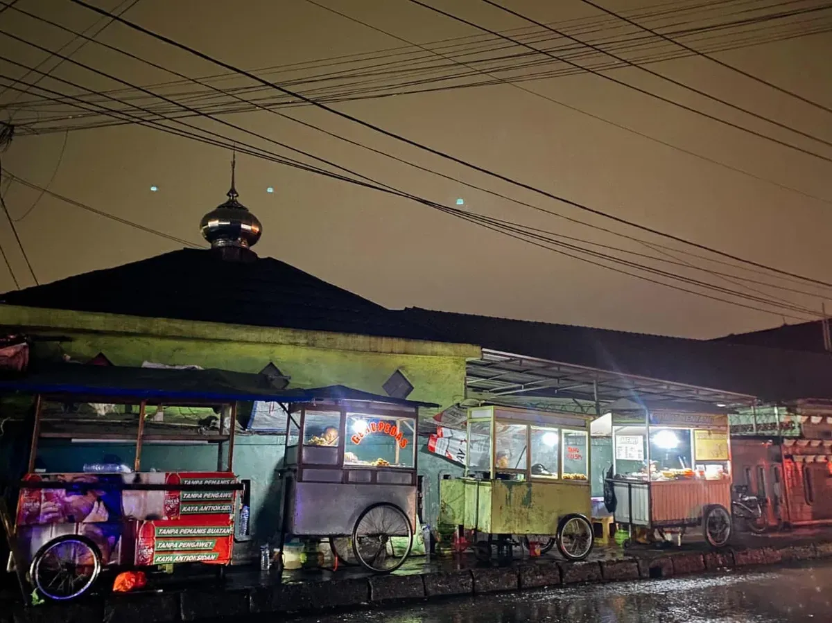 Sejumlah pedagang kaki lima yang tetap berjualan meski hujan di malam hari di kawasan Caringin 30-11-2025 (Sumber: Dokumentasi Penulis | Foto: Raifan Firdaus Al Farghani)