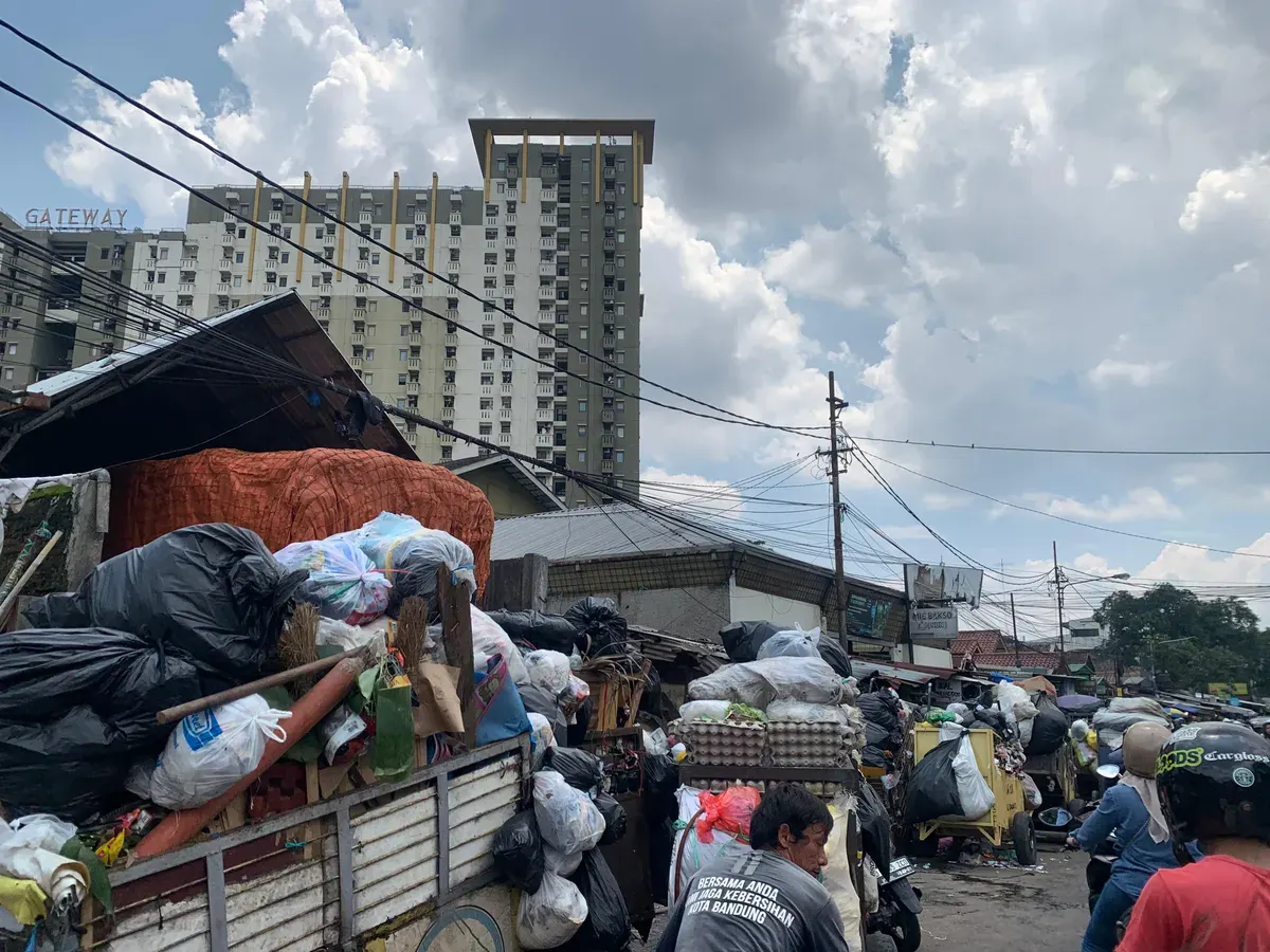 Kondisi tumpukan sampah menutupi badan jalan di kawasan Pasar Cicadas pada siang hari, (30/11/2025), sehingga mengganggu aktivitas warga dan pedagang di sekitar lokasi. (Foto: Adinda Jenny A)