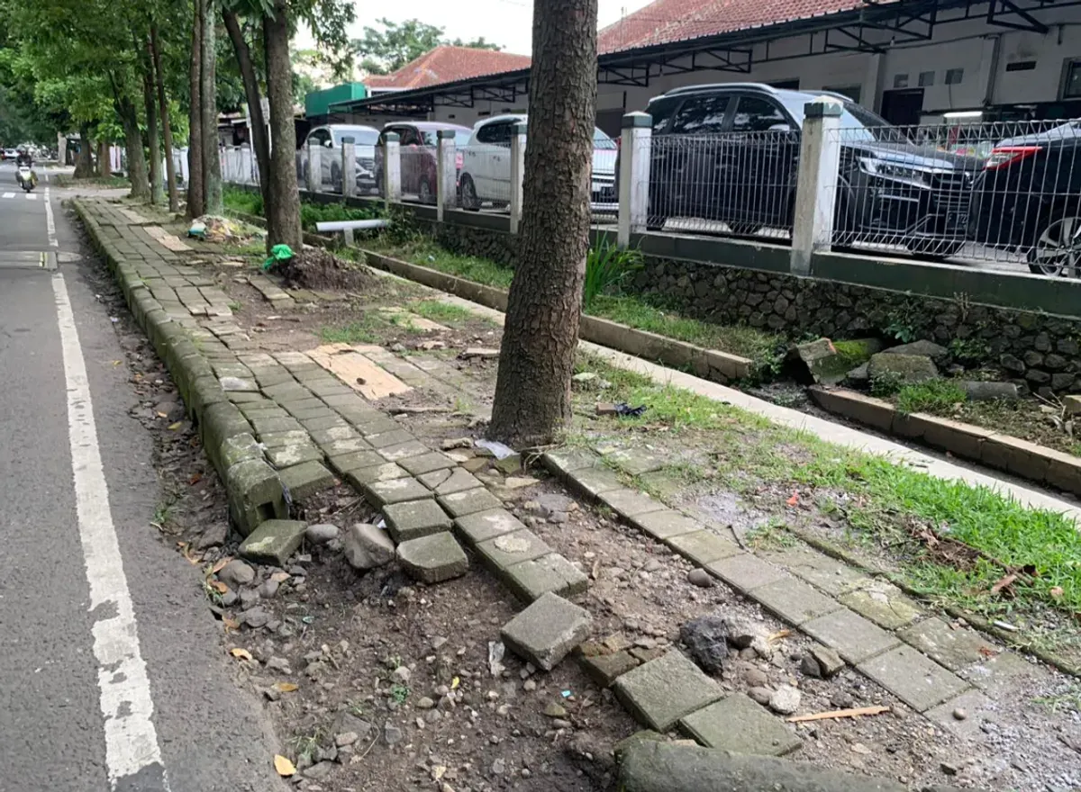 Salah satu keadaan guiding block yang terputus, rusak bahkan tertutup pohon di trotoar Jl. Gudang Utara, Kecamatan Sumur Bandung, Kota Bandung (3/12/25) (Foto: Fasha Nadira Syakir)