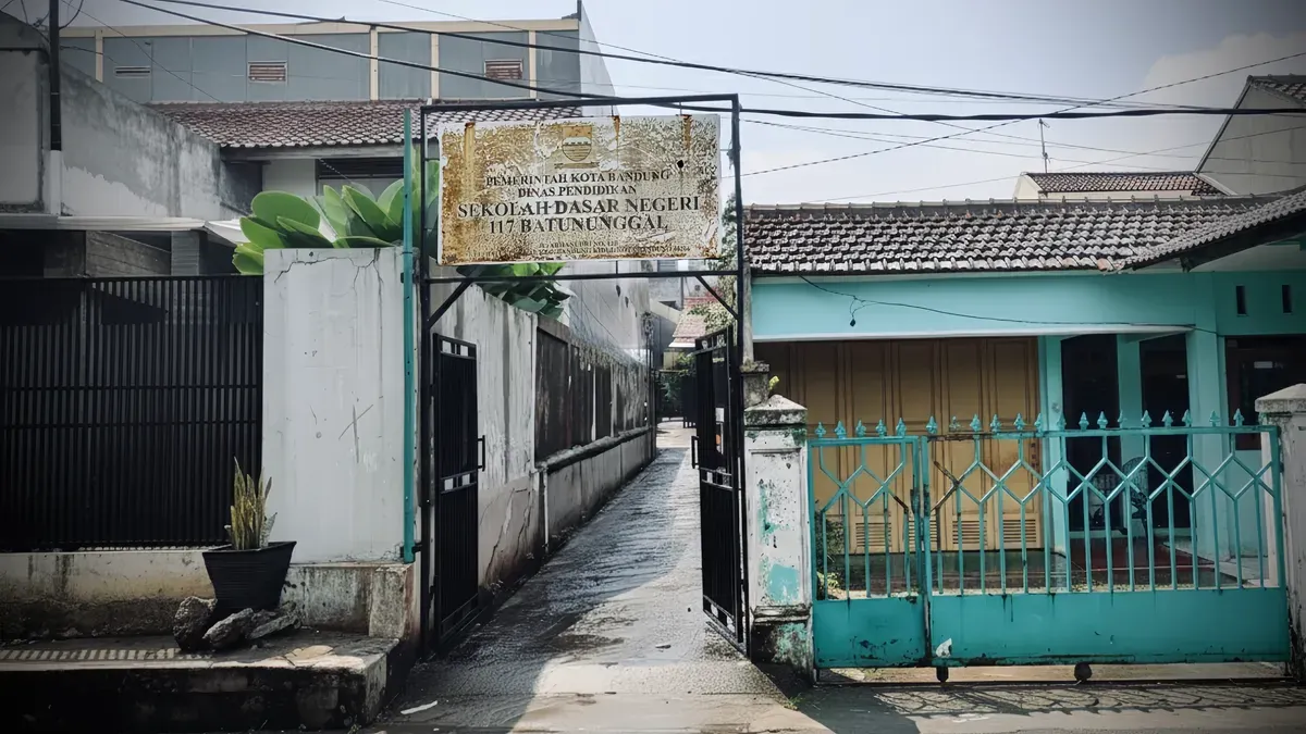 Akses masuk SDN 117 Batununggal yang terlihat sepi usai hujan menyisakan genangan air di area jalan masuk, Kecamatan Batununggal, Kota Bandung. (4/12/2025) (Sumber: Raveyfa Shinta | Foto: Raveyfa Shinta)