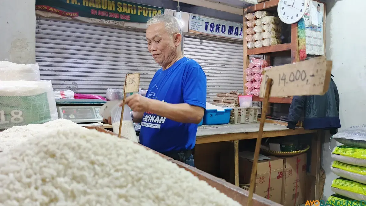 Rahmat Kurnia (52) tengah menyiapkan sekantong plastik beras untuk pembeli di Pasar Kosambi, Kota Bandung. (Sumber: ayobandung.id | Foto: Gilang Fathu Romadhan)