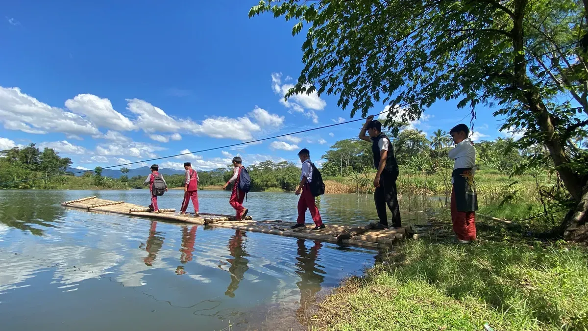Sejumlah siswa SD pergi sekolah menaiki rakit bambu melintasi Waduk Saguling. (Sumber: Ayobandung | Foto: Restu Nugraha)