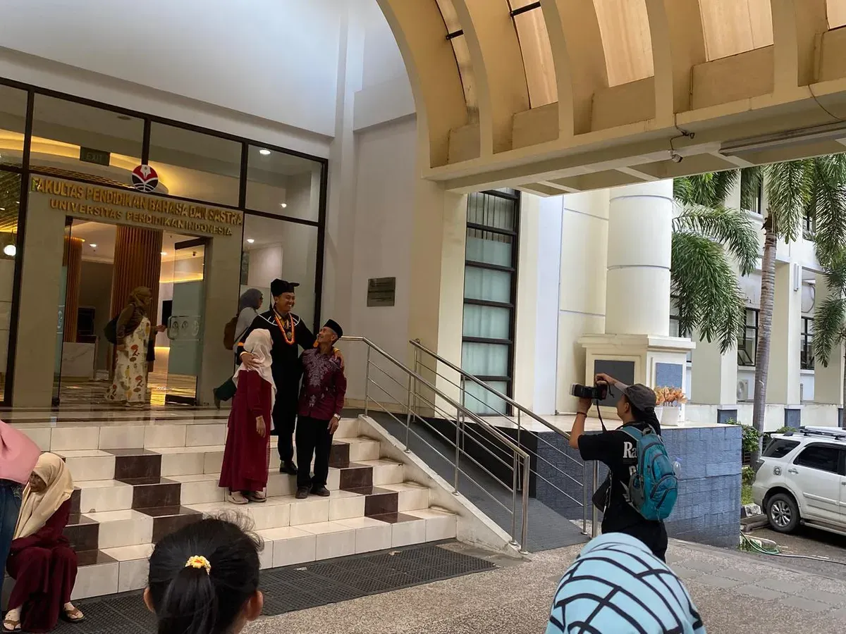 Seorang wisudawan berpose bersama keluarganya di depan Fakultas, Universitas Pendidikan Indonesia, Bandung. (Sumber: Dokumentasi Pribadi | Foto: Jajang Shofar Khoerudin)