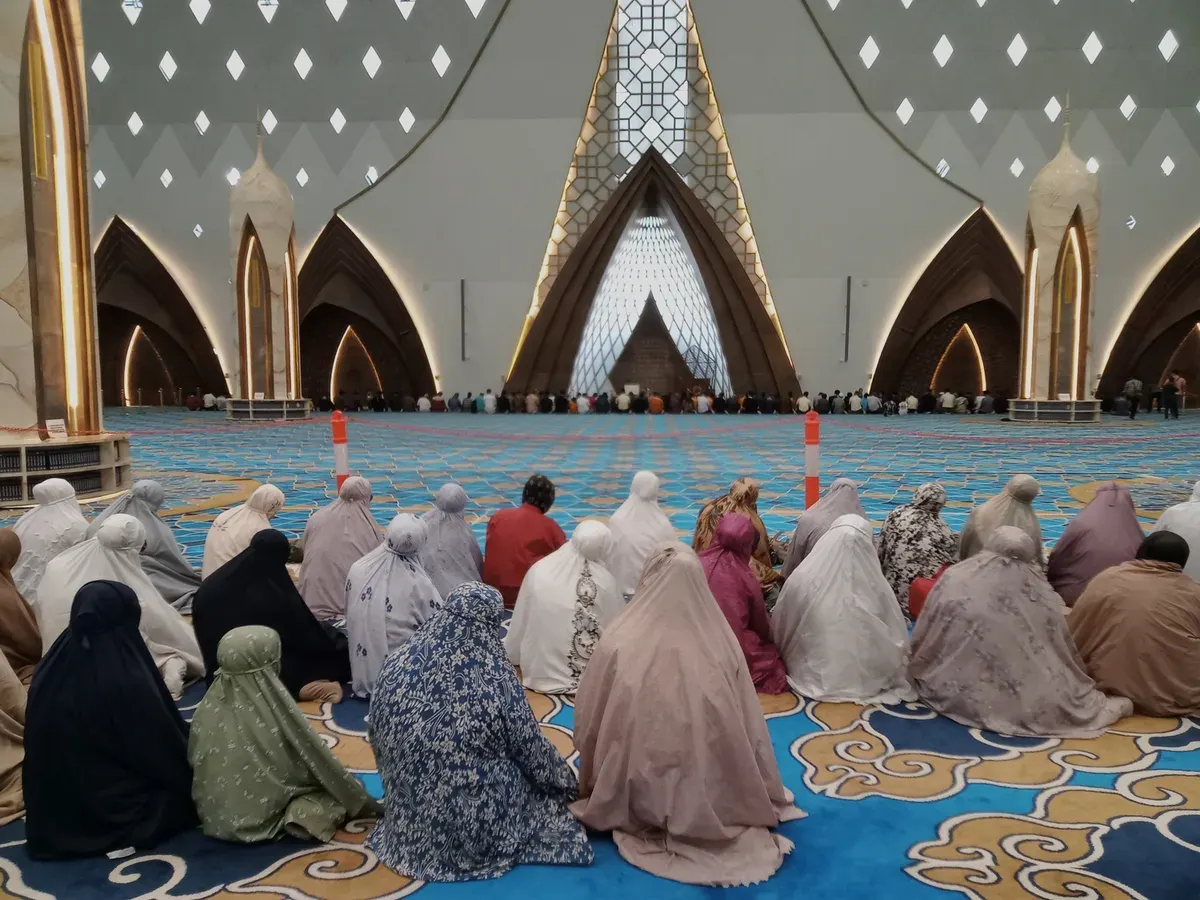 Di tengah sore mendung yang adem, Masjid Al Jabbar menjadi ruang jeda, tempat jamaah larut dalam ketenangan, di bawah cahaya lembut dan arsitektur megah yang memeluk suasana dengan damai (Foto: Syahiratul Mghfiroh)