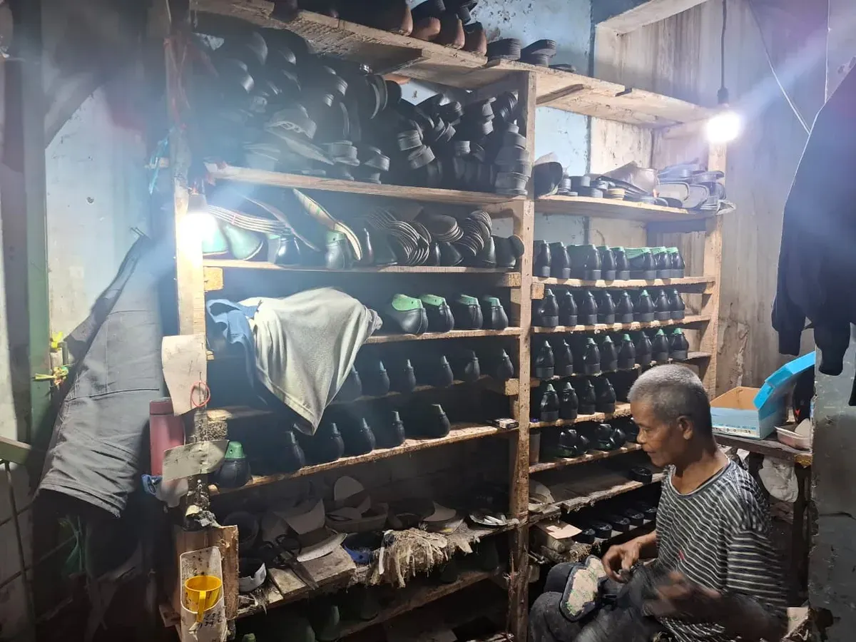 Seseorang tengah menempel alas sepatu kulit di rumah produksi Sepatu Persada
(01/09/2025) (Sumber: Khalidullah As Syauqi)