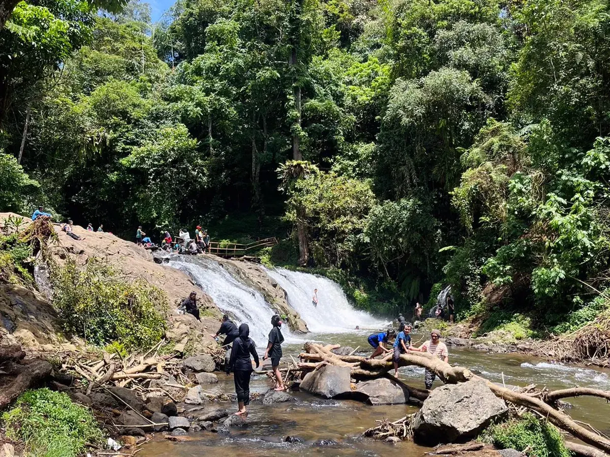 Derai air Curug Layung mengiringi langkah pengunjung saat bermain di antara bebatuan pada 9 November 2025 di Desa Kartawangi, Kecamatan Cisarua, Kabupaten Bandung Barat. (Sumber: Humaira Mazaya | Foto: Humaira Mazaya)