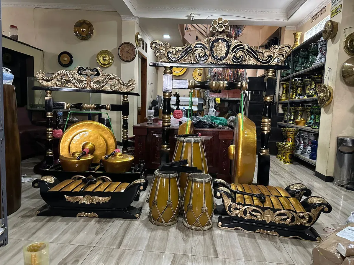 Pengrajin Giri Purwa Seni menampilkan seperangkat alat musik tradisional berwarna keemasan di ruang pamer Giri Purwa Seni, Jl. Soekarno Hatta No. 425, Desa Cigereleng, Astana Anyar, Karasak, pada Senin, 10 November 2025. (Sumber: Dokumentasi Penulis)