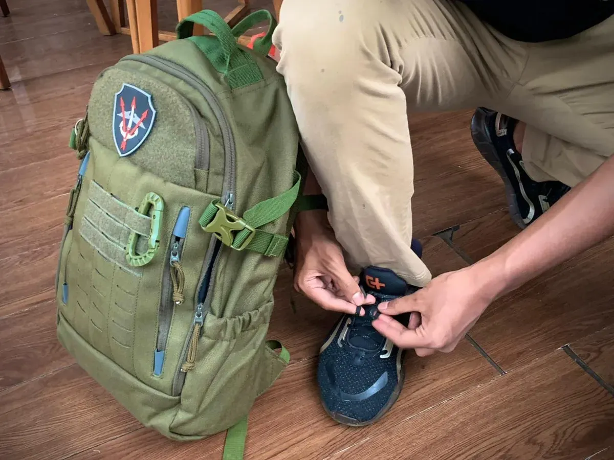 Dyvo Xavier Muhamad Yandi Putra sedang mengikat tali sepatunya sambil membawa tas ransel Cartenz Tactical di sampingnya .(Foto: Patricia Avrilia Rolina)