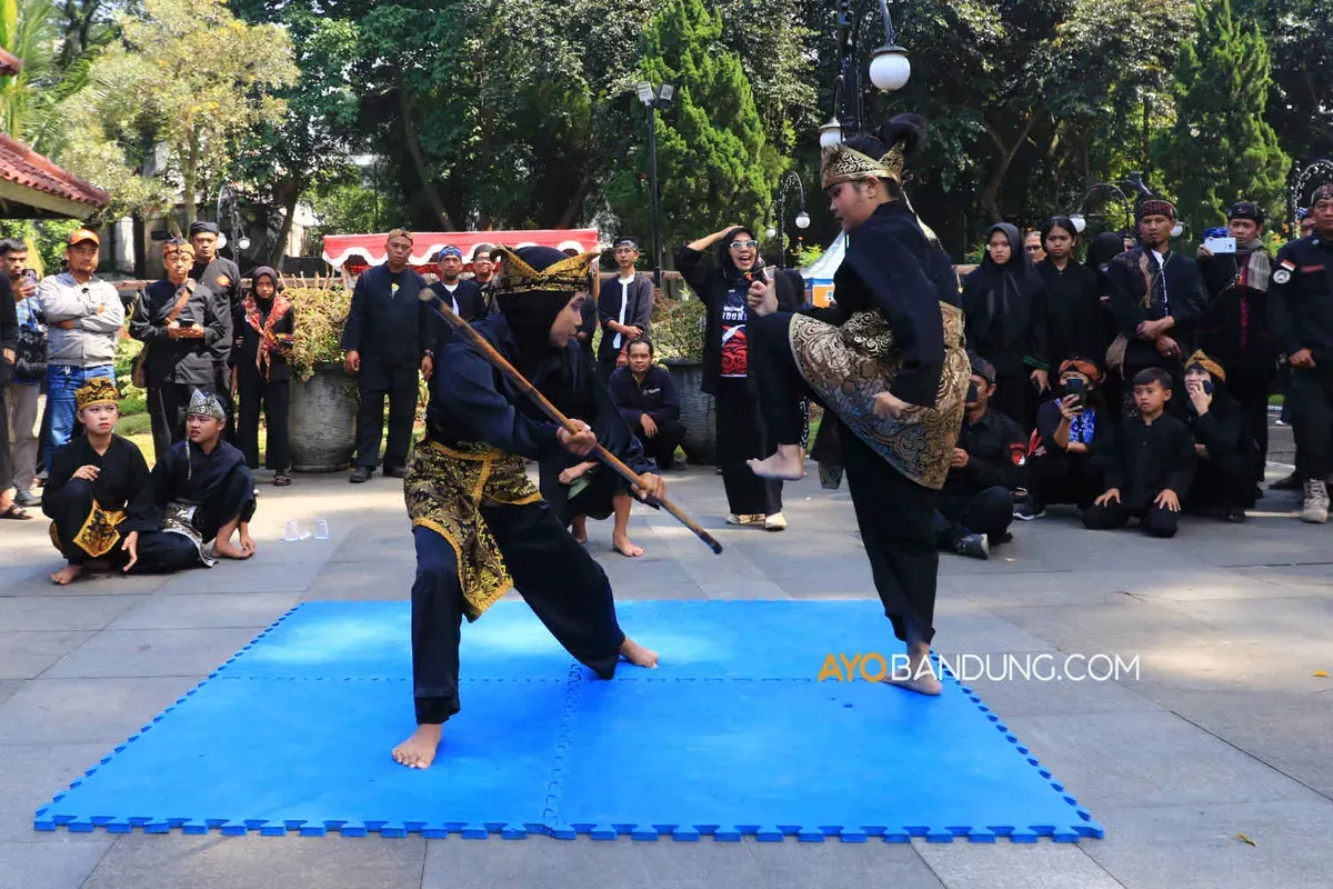 Pesilat dari Paguron Gajah Putih Baleendah menampilkan gerakan pencak silat pada gelaran Bandung Lautan Pangsi, Selasa 11 Juli 2023. (Sumber: Ayobandung.com | Foto: Irfan Al-Faritsi)