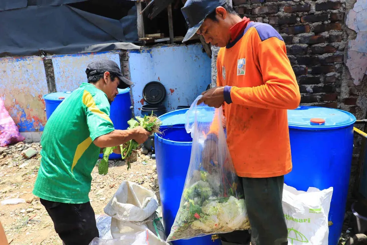 Petugas memasukan sampah organik ke dalam drum komposter di Pasar Sederhana, Kota Bandung, Selasa 15 Oktober 2024. (Sumber: Ayobandung.id | Foto: Irfan Al-Faritsi)