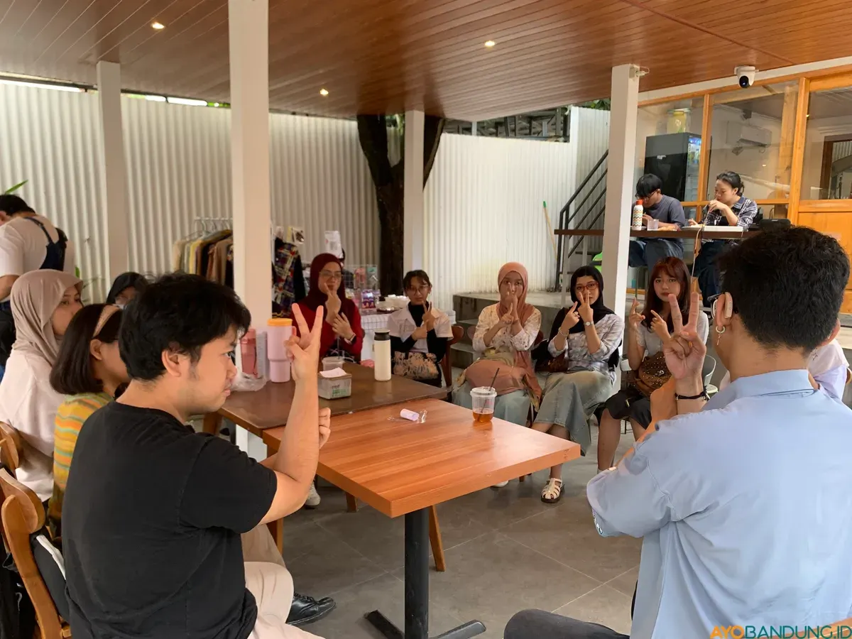 Suasana ngobrol Komunitas Karya Seni Tuli dipenuhi gerakan tangan, tawa tanpa suara, dan interaksi yang terjalin lewat bahasa isyarat. (Sumber: ayobandung.id | Foto: Halwa Raudhatul)