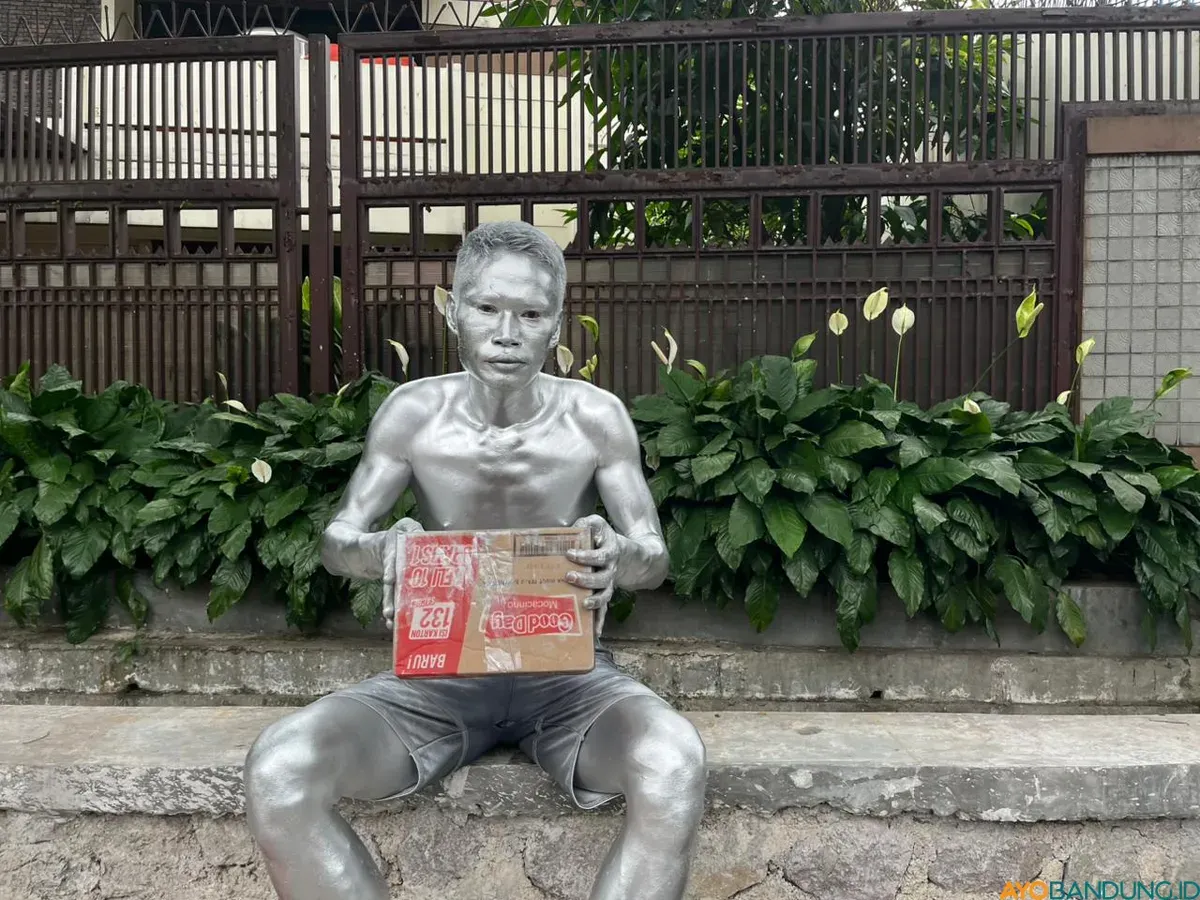 Erwin melumuri badanya mengggunakan tinta sablon plastik berbahan kimia yang dicampur minyak goreng. (Sumber: ayobandung.id | Foto: Ilham Maulana)