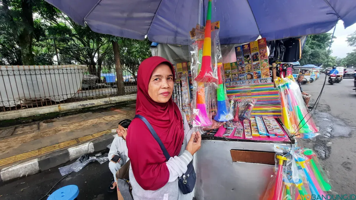 Sanidah berjualan terompet di sekitar Taman Tegalega, Kota Bandung. (Sumber: ayobandung.id | Foto: Nisrina Nuraini)