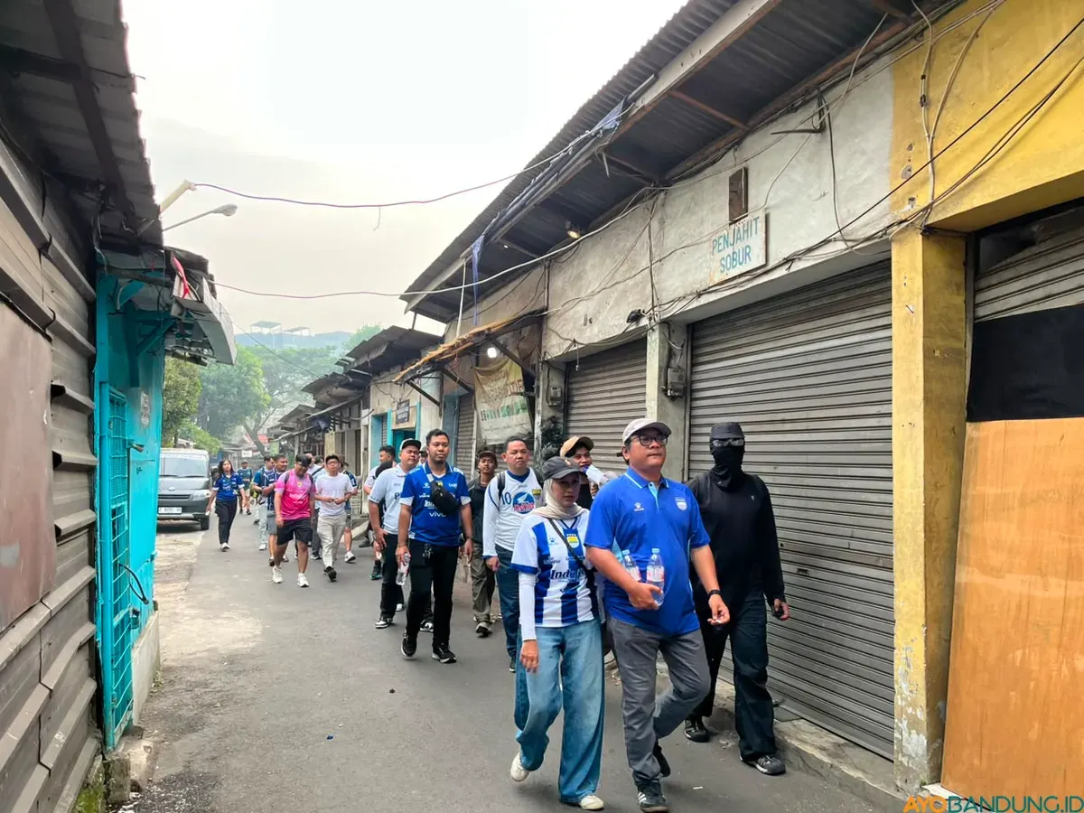 Peserta Bobotoh Story Walk menyusuri jalanan Bandung sambil mendengarkan kisah-kisah yang membentuk sejarah Persib. (Sumber: ayobandung.id | Foto: Ilham Maulana)
