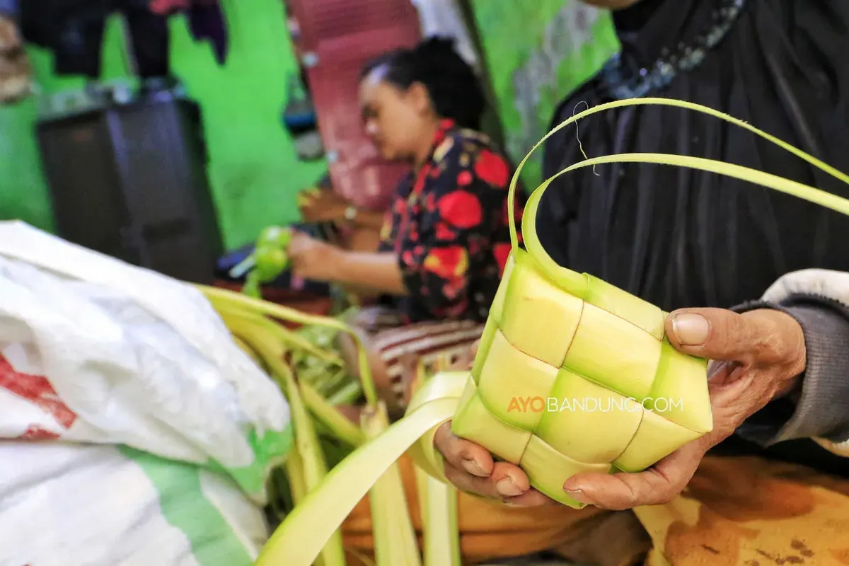 Warga menganyam daun kelapa menjadi cangkang ketupat di kawasan Blok Ketupat, Caringin, Kecamatan Babakan Ciparay, Kota Bandung. (Sumber: Ayobandung.com | Foto: Irfan Al-Faritsi)