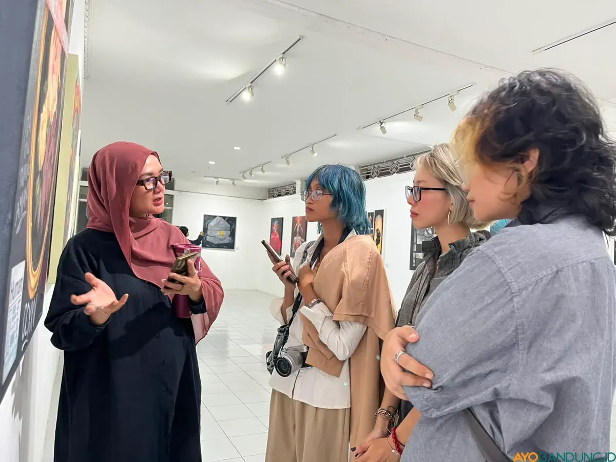 Ima Suswanto menjelaskan makna di balik salah satu karya yang dipamerkan dalam pameran NeoFemisida kepada pengunjung. (Sumber: ayobandung.id | Foto: Ilham Maulana)
