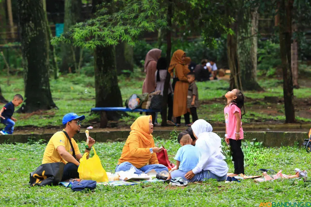 Warga memanfaatkan ruang terbuka hijau di Kebun Binatang Bandung untuk bersantai dan makan bersama. (Sumber: ayobandung.id | Foto: Irfan Al Faritsi)