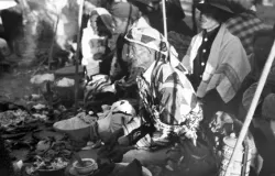 Dukun bermantel tambal sulam memberkati sesaji dalam salah satu festival di jawa pada masa Kolonial. (Sumber: Tropenmuseum)